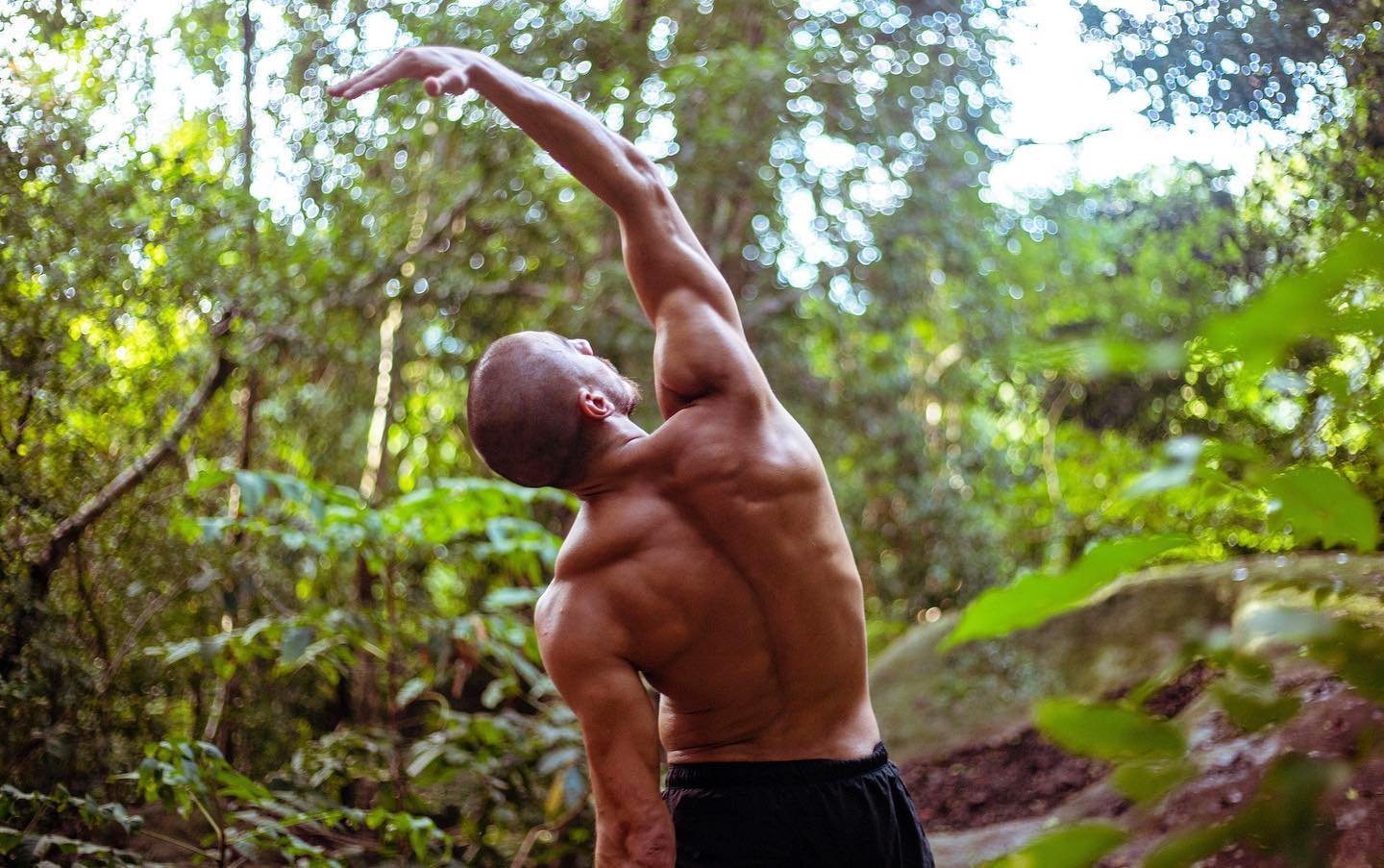 Mohammed F. Mostafa mid-stretch, arm overhead, in the jungle